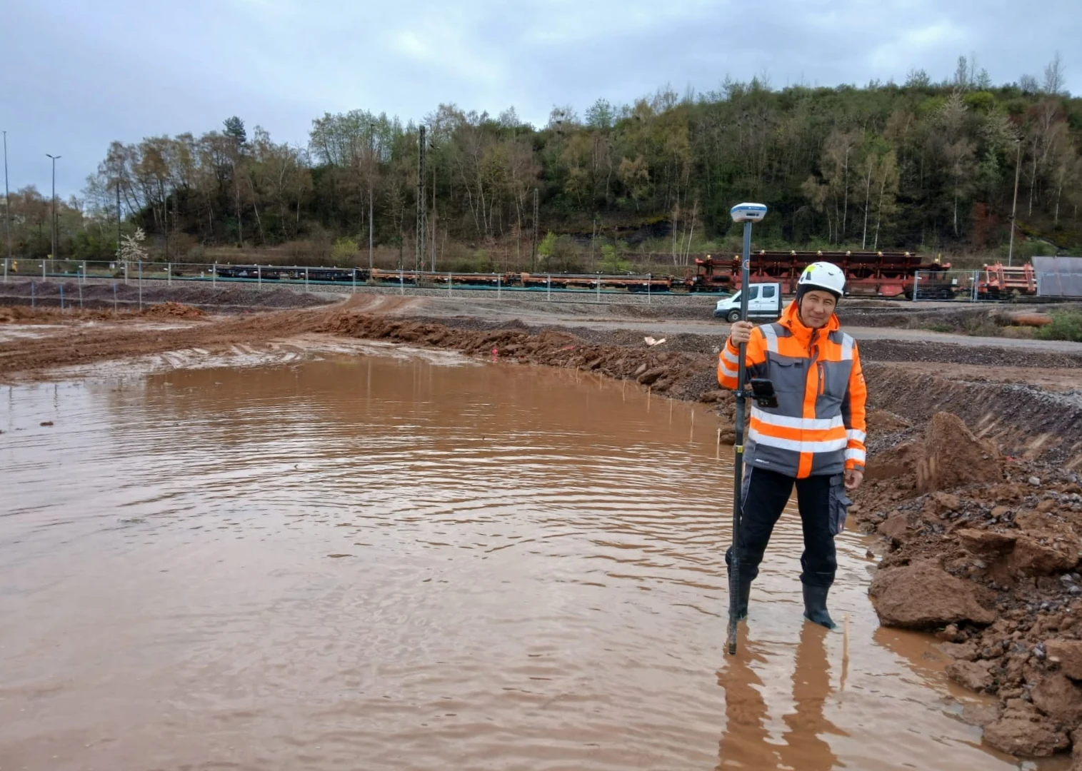 Vermessung mit GNSS-Stab auf einer Baustelle.